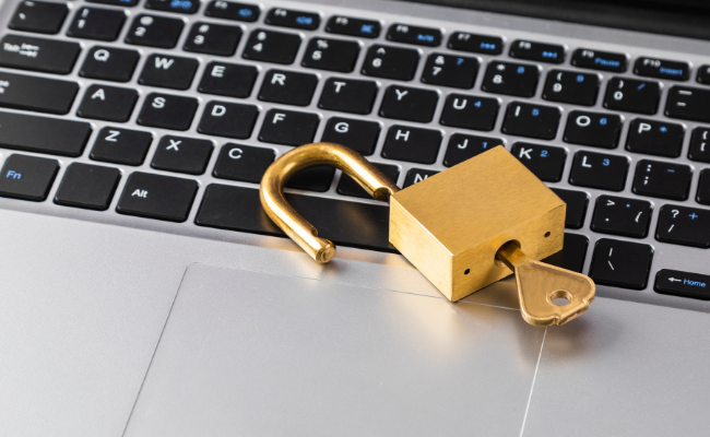 laptop keyboard with a golden lock and key resting on it