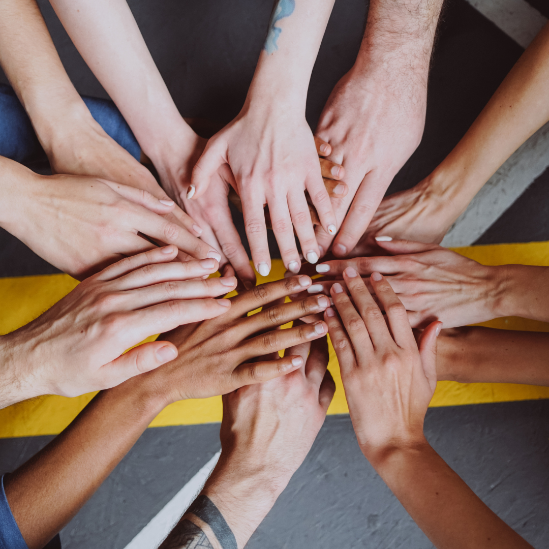 overhead shot of multiple hands together in a pile, decorative